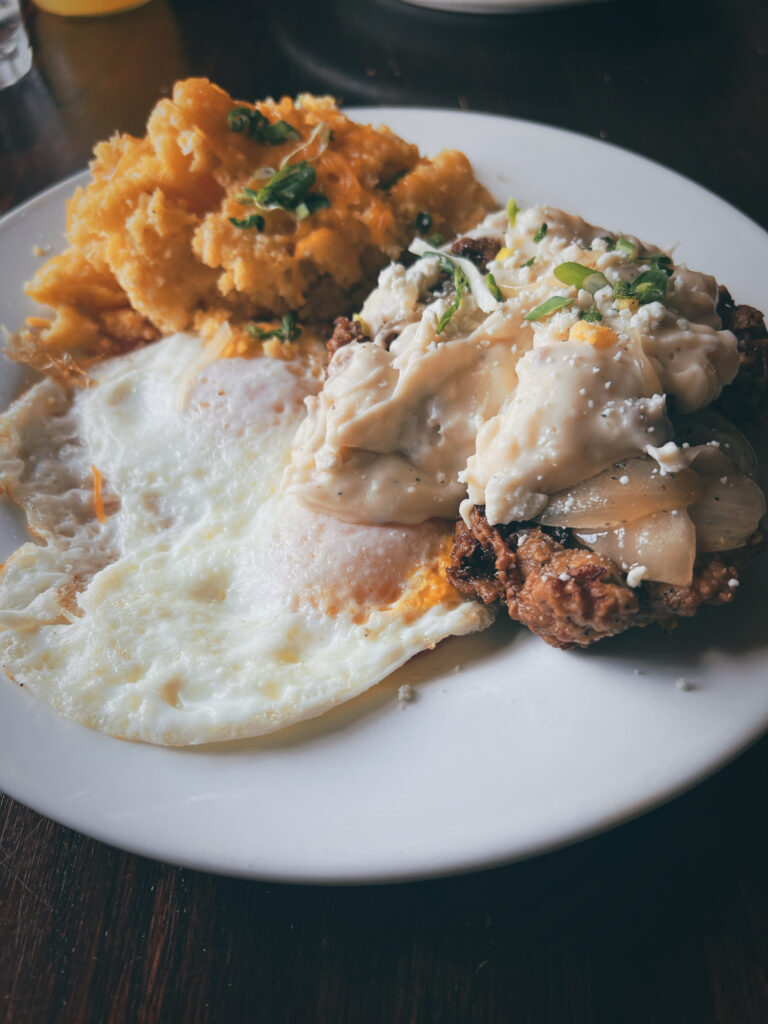 Captain Duane's Buttermilk Country Fried Steak with Bacon Cheddar Grits, eggs over medium, and that gravy! 